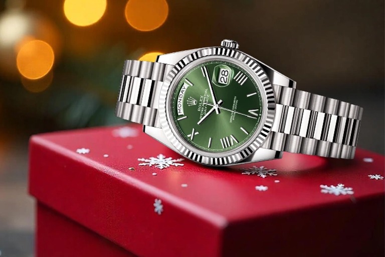Rolex Day-Date con quadrante verde appoggiato su una confezione regalo natalizia, simbolo degli orologi di lusso usati a Roma come idea perfetta per Natale 2025.
